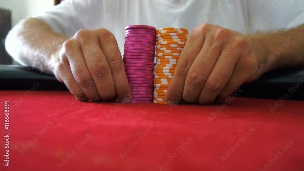Pushing pile of poker chips towards camera. Slow motion