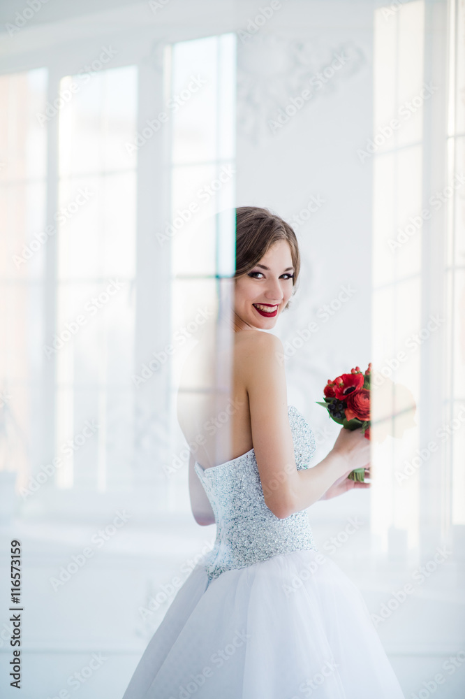 young and beautiful fashion art photo of a bride in white dress in living room. Shot through the glass door, light creative reflections overlay portrait. young and beautiful fashion art photo of a bride in white dress in living room. Shot through the glass door, light creative reflections overlay portrait.
