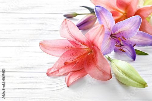 Fototapeta Naklejka Na Ścianę i Meble -  Beautiful lilies on light wooden background