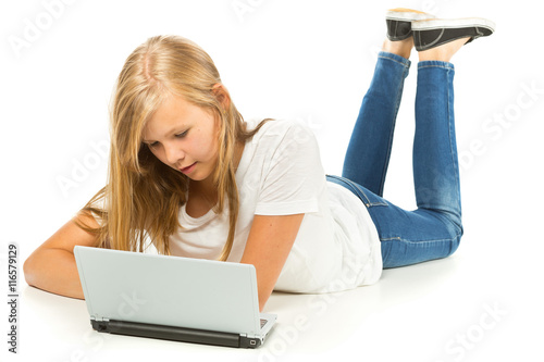 Young girl lying on the floor using laptop over white background