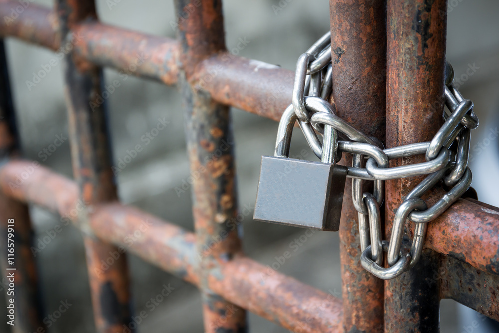Old lock pad locked on fence with chain. Old lock pad locked on fence with chain.