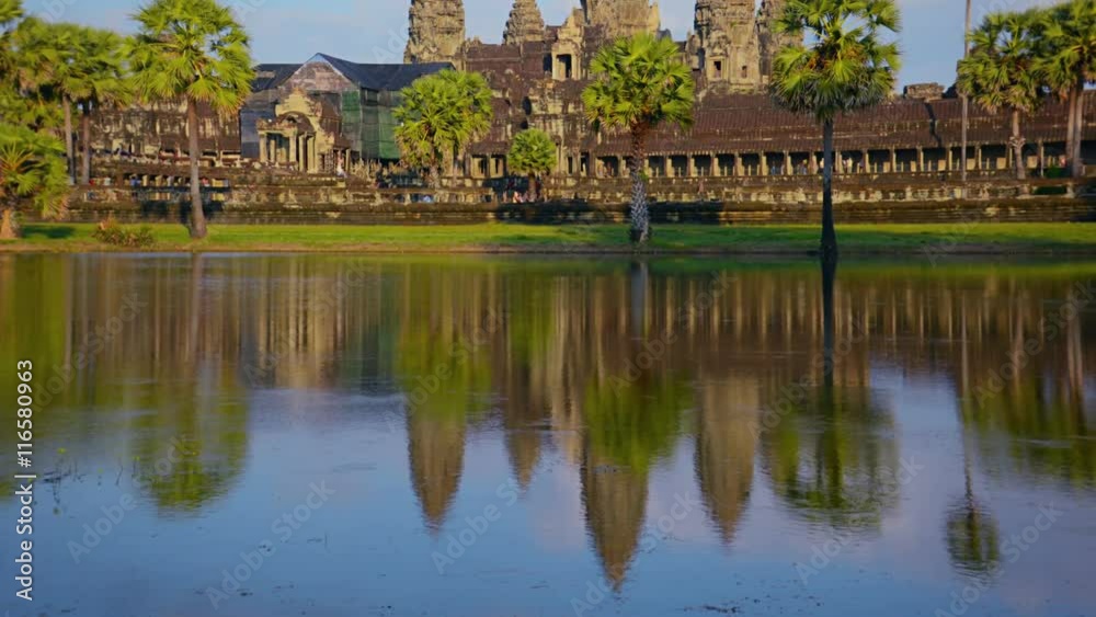 Video UHD - Slow, upward tilting shot of Angkor Wat Temple in Siem Reap, Cambodia. The panoramic view in time-lapse shows tourists and traffic. Video UHD - Slow, upward tilting shot of Angkor Wat Temple in Siem Reap, Cambodia. The panoramic view in time-lapse shows tourists and traffic.