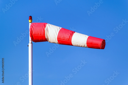 Airport windsock on clear blue sky background in windy weather indicate the local wind direction (also called: air sock, drogue, wind sleeve, wind cone)
