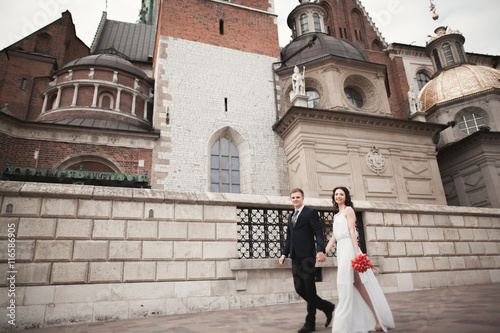 Wedding couple, bride and groom walking near a church in Krakow © olegparylyak
