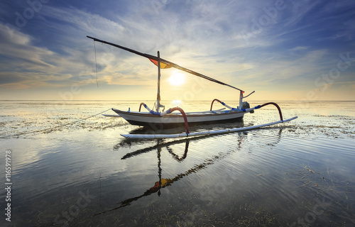 Fishing boats populate the shoreline at the Sanur Beach, bali, indonesia photo