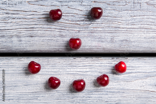 Smiley made of cherries. Red fruit on wooden surface. Make your immunity stronger. Summer welcomes you.