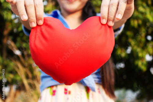 Big red heart and background of girl or women hands