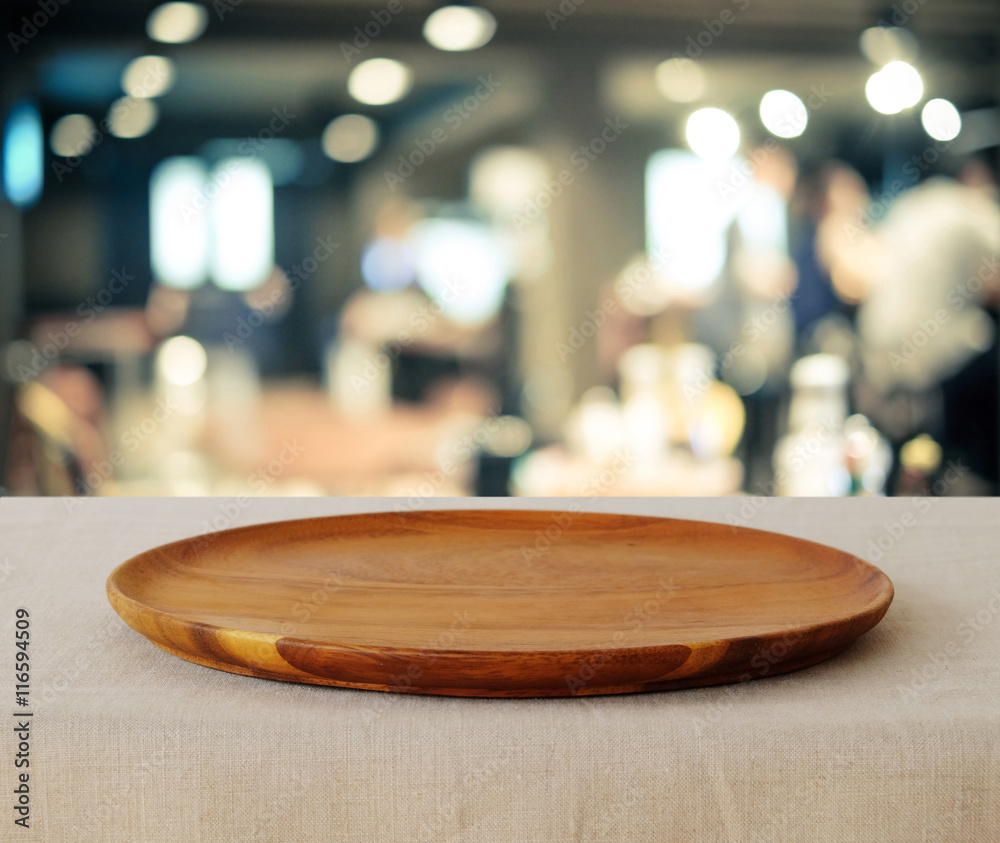 Empty wooden round tray over blurred cafe background Empty wooden round tray over blurred cafe background