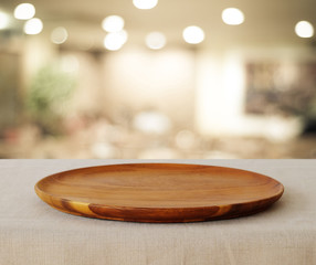 Empty wooden round tray over blurred cafe background