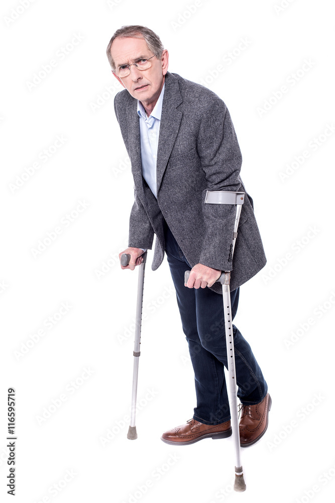 Elderly man walking with the help of crutches Elderly man walking with the help of crutches