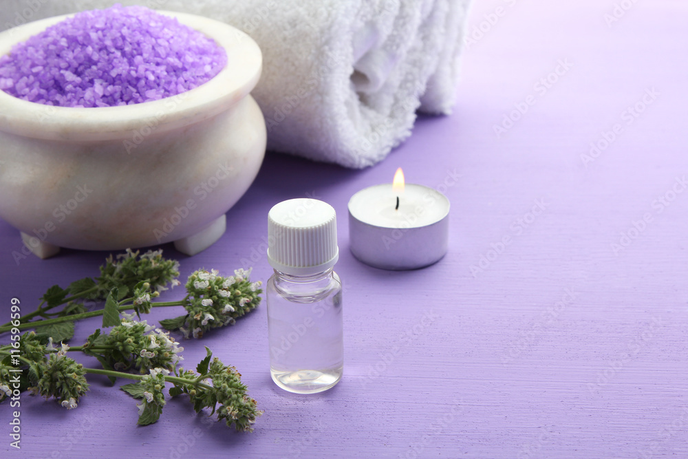 Essential oil with aromatic salt on a purple background. The concept of aromatherapy. Essential oil with aromatic salt on a purple background. The concept of aromatherapy.