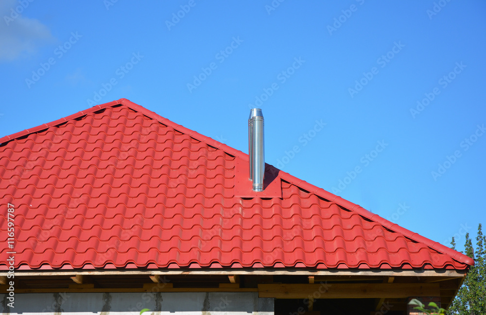 New red metal tiled roof with steel chimney house roofing construction exterior without rain gutter system.