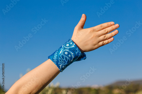 female hand with blue bandana