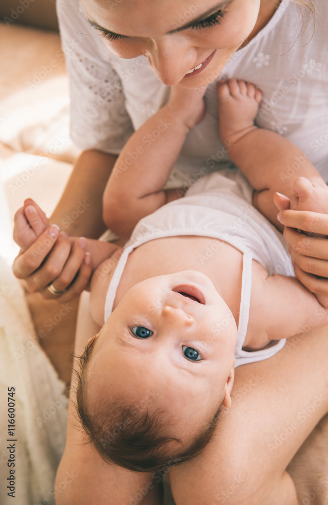 Close-up portrait of young mom and child laughing and playing at home. Close-up portrait of young mom and child laughing and playing at home.