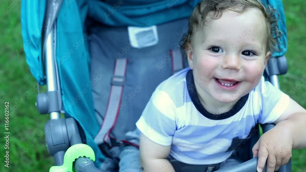 Nice Baby smiling in the stroller on the garden 