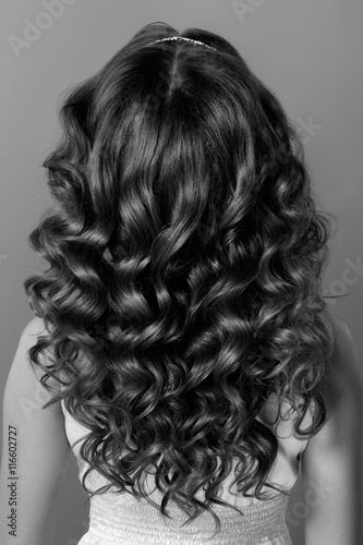 Fashion portrait of young woman with magnificent curly hair. Per