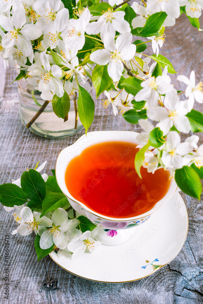 Cup of tea on wooden table and apple blossom Cup of tea on wooden table and apple blossom