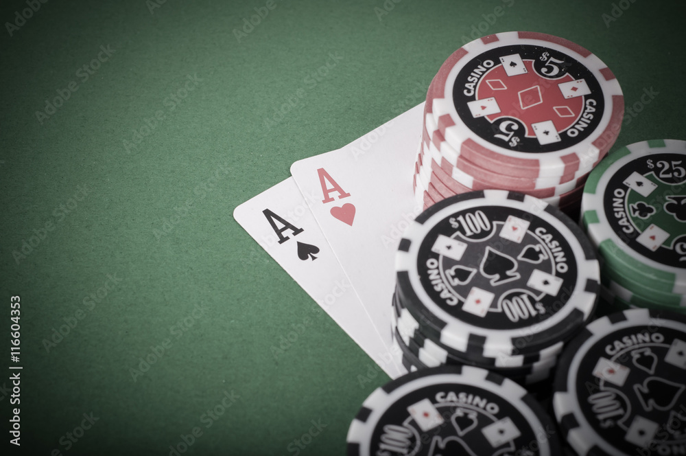pair of aces, red and black cassino chips on green table - vinta