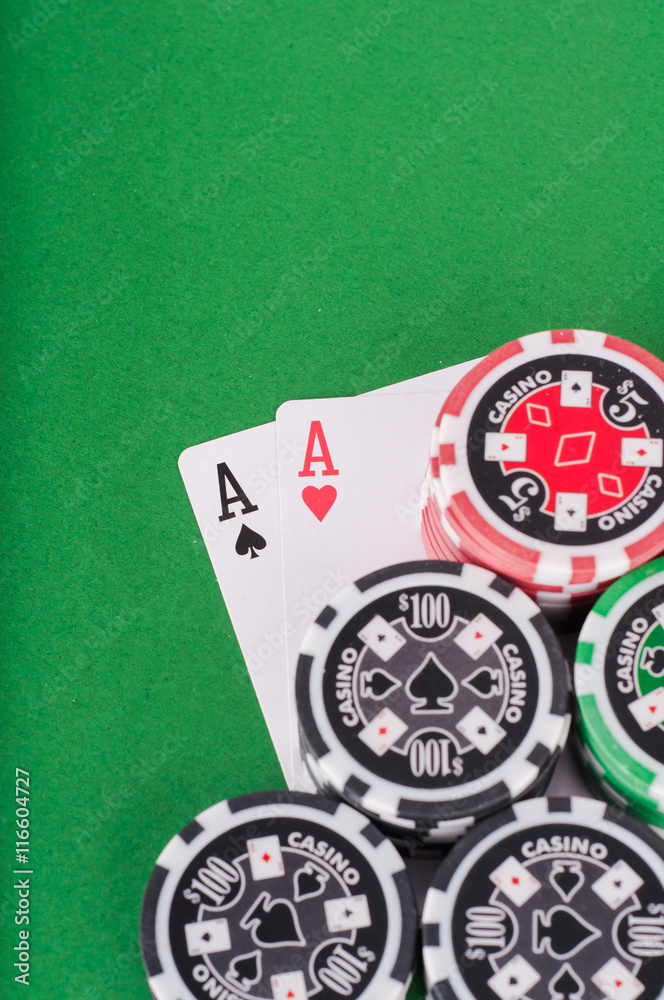 pair of aces, red and black cassino chips on green table pair of aces, red and black cassino chips on green table