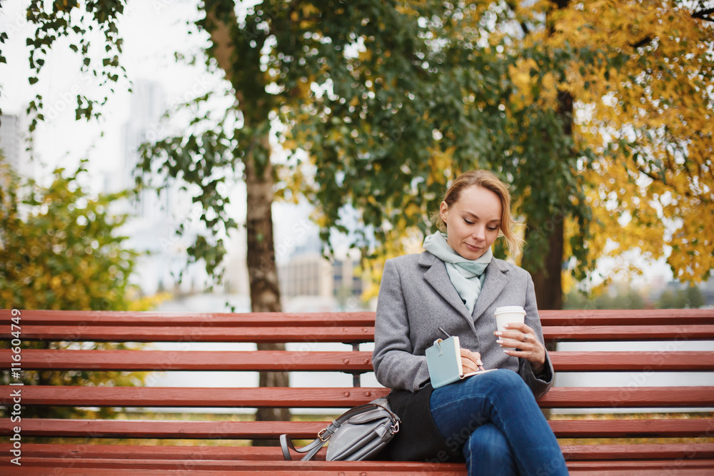 Trendy woman in stylish coat sitting