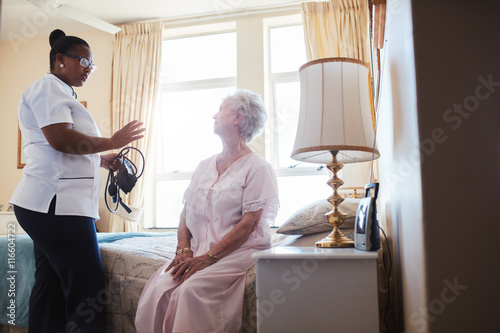 Female doctor visiting her senior patient at home