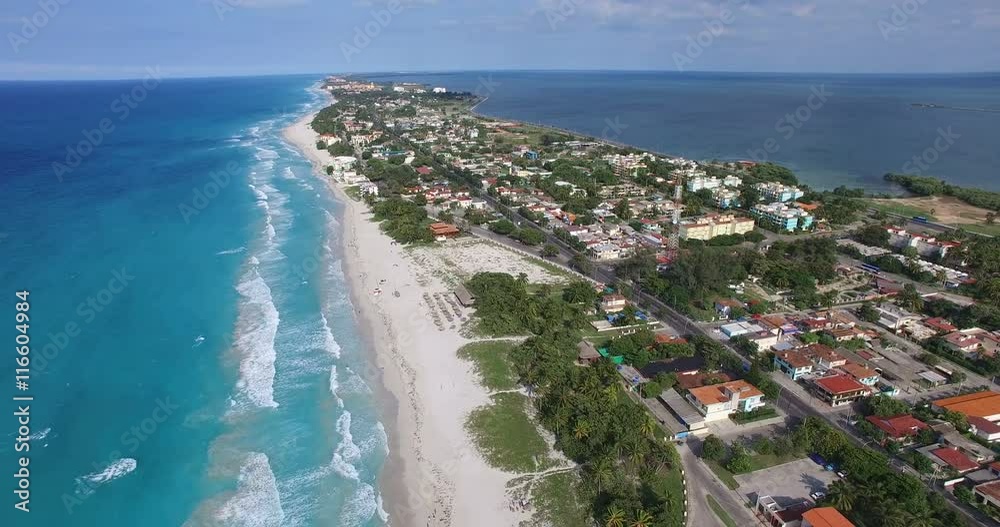 VARADERO, CUBA - MAY 21, 2016: Drone flies over tropical island on a clear day. Calm Atlantic Ocean and the bay. Flying over the city. On the road going car, close to the shore. Height of 500 meters VARADERO, CUBA - MAY 21, 2016: Drone flies over tropical island on a clear day. Calm Atlantic Ocean and the bay. Flying over the city. On the road going car, close to the shore. Height of 500 meters