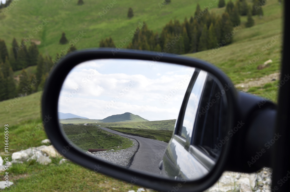 Lonely road seen through rear mirror