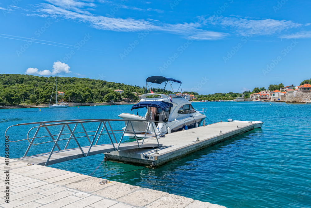 Obraz premium Small boat anchored in the Prvic Luka port at beautiful summer day in Croatia.