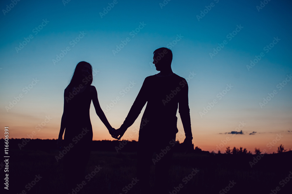 Love story . Couple at sunset. On the background of the sky. Clouds.