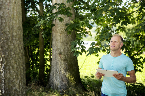 Man in the woods with Tablet PC