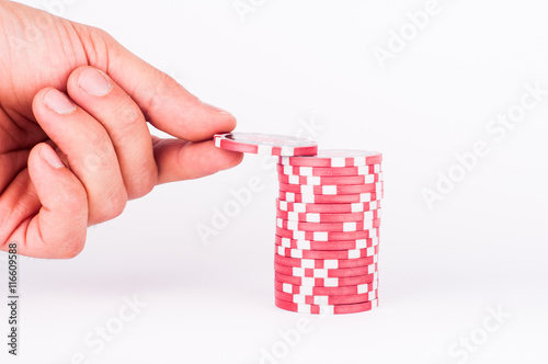 Human hand takeing red casino chips isolated on white photo