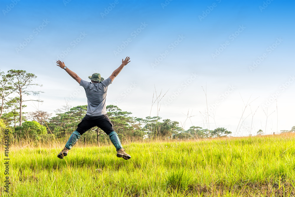 Happy young man hiker jumping on a green field. Happy young man hiker jumping on a green field.