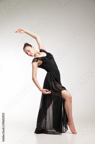 Young ballet dancer wearing black transparent dress dancing 