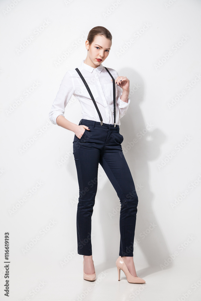 fashion model in black trousers and top posing over white