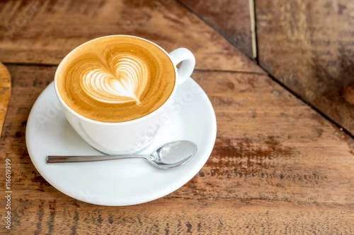 Obraz Zamknij się biały kubek kawy z latte art kształcie serca na karcie drewna