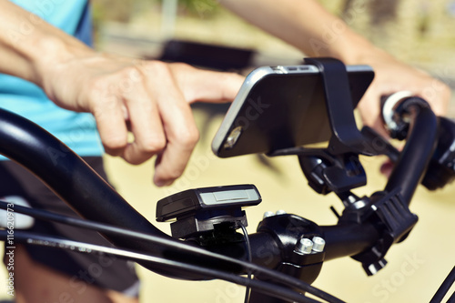 young man using a smartphone riding a bicycle
