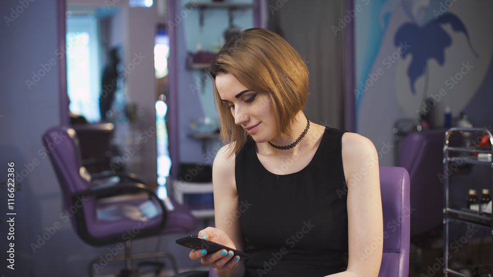 Fototapeta premium beauty, hairstyle and people concept - happy young woman with smartphone.