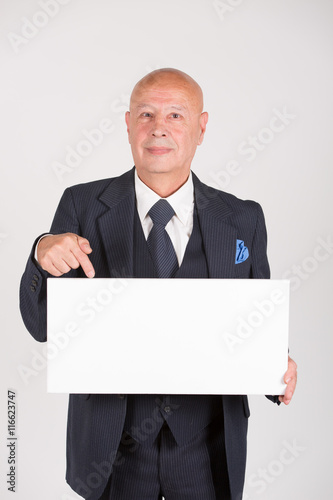 Älterer Mann / Senior hält weißes Schild mit Platz für Text