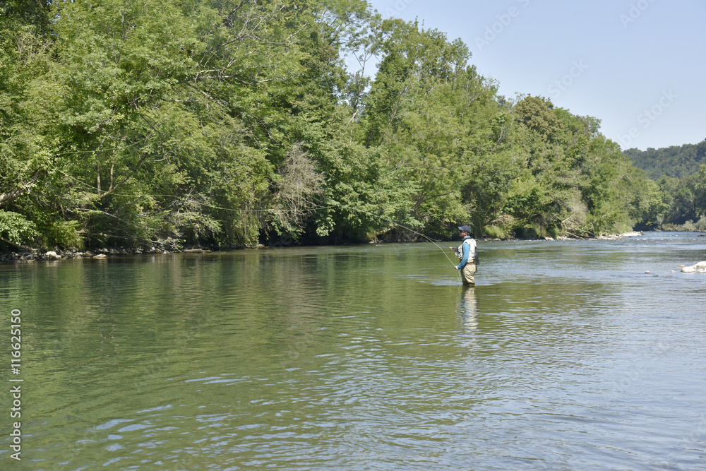 Flyfisherman fishing in mountain river Flyfisherman fishing in mountain river