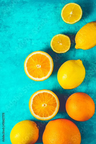 Lemons and oranges on the cyan background vertical © deniskarpenkov