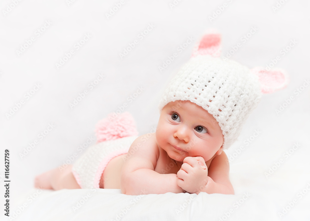 studio portrait on a blanket of a caucasian baby girl. with wool hat with bunny ears. studio portrait on a blanket of a caucasian baby girl. with wool hat with bunny ears.