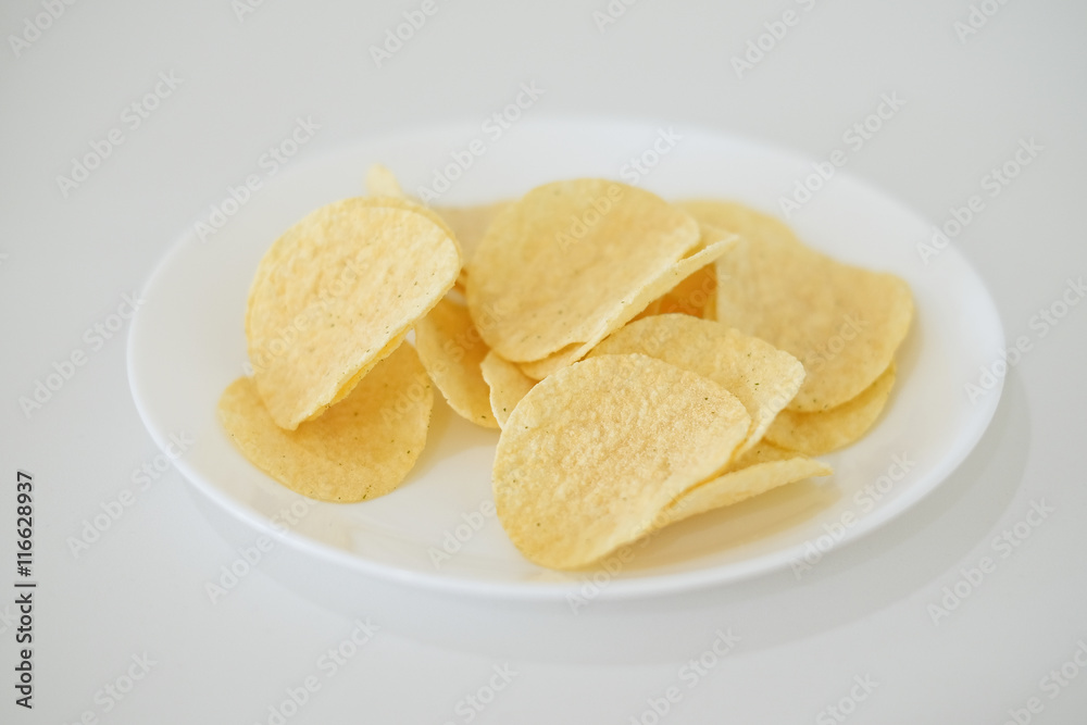 snack food of potato chips crispy in white ceramic bowl on white background snack food of potato chips crispy in white ceramic bowl on white background