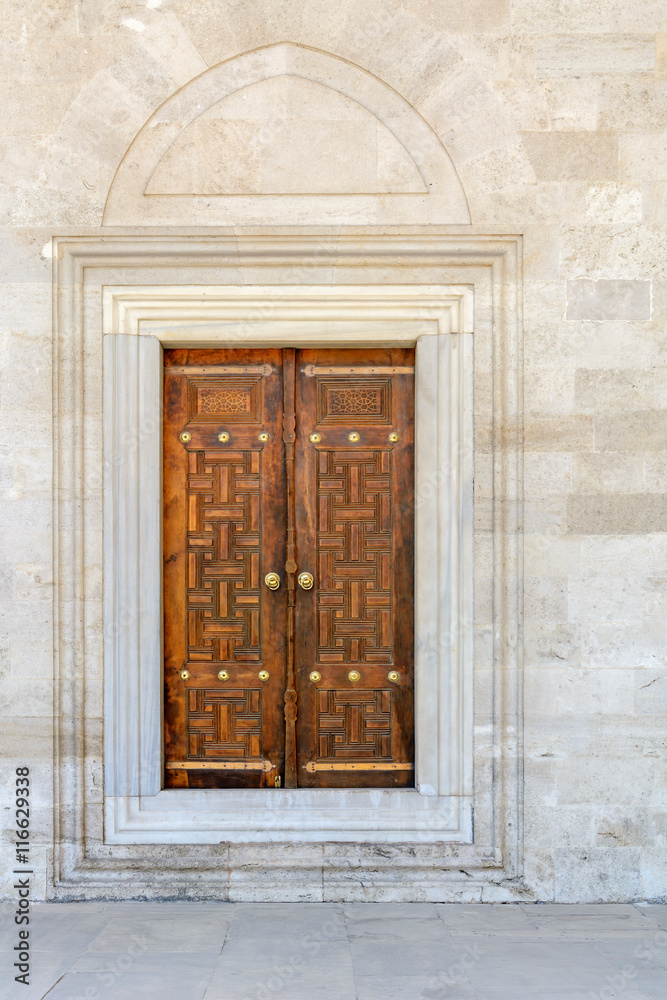 Fototapeta premium Old Wooden Door on Grunge sandstone Wall. Temple.