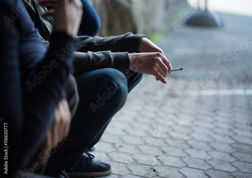 close up of young men smoking cigarettes