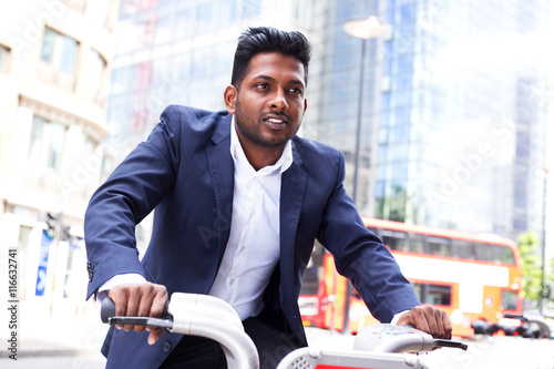 Photography Indian business man riding a london hirebike