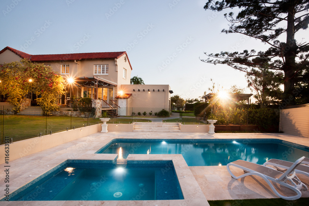 Modern swimming pool area with lights from a mansion - obrazy, fototapety, plakaty 