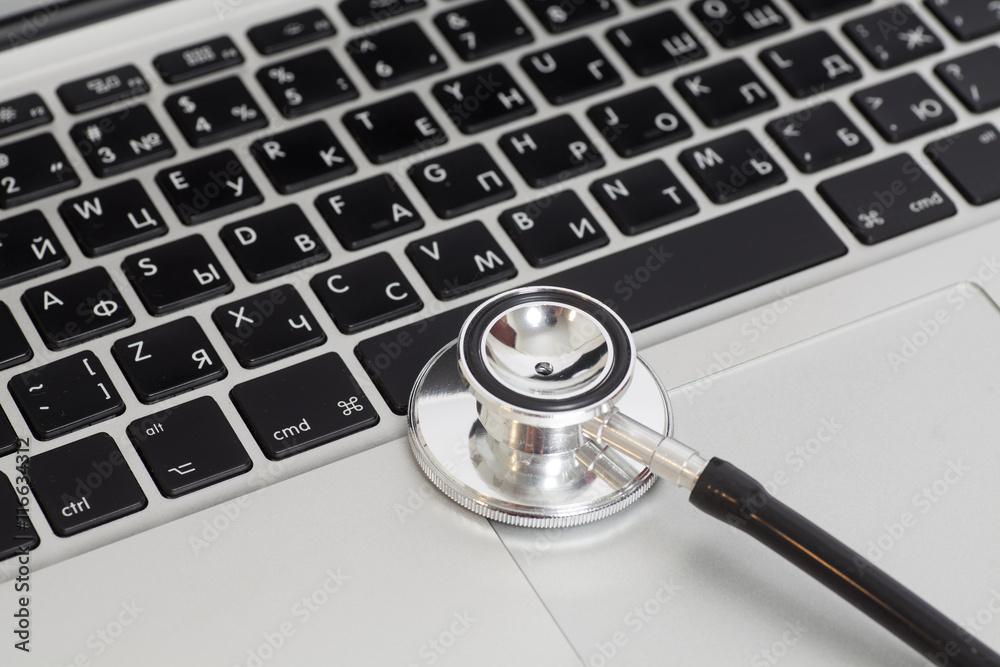 Medical stethoscope on a laptop computer, close up Medical stethoscope on a laptop computer, close up