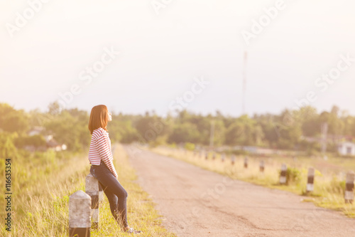 Young woman unhappy sitting on road in the reservoir.