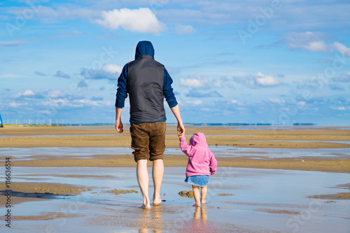 Mann und Kind machen einen Spaziergang am Meer photo