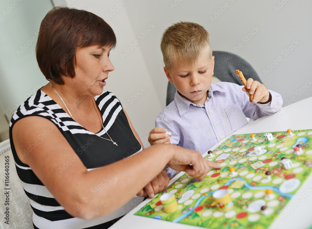 Little boy play board gamrme with his grandmother Little boy play board gamrme with his grandmother